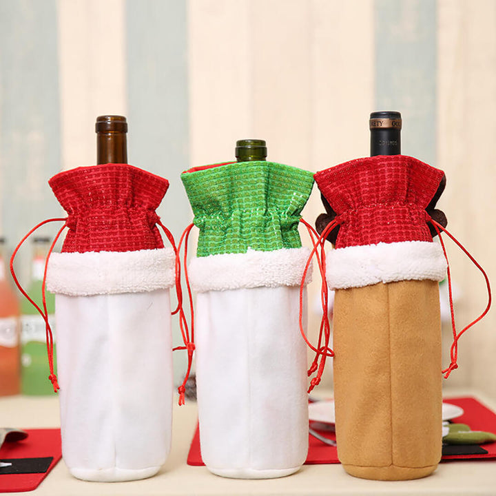 Three wine bottles wrapped in festive covers on a table.