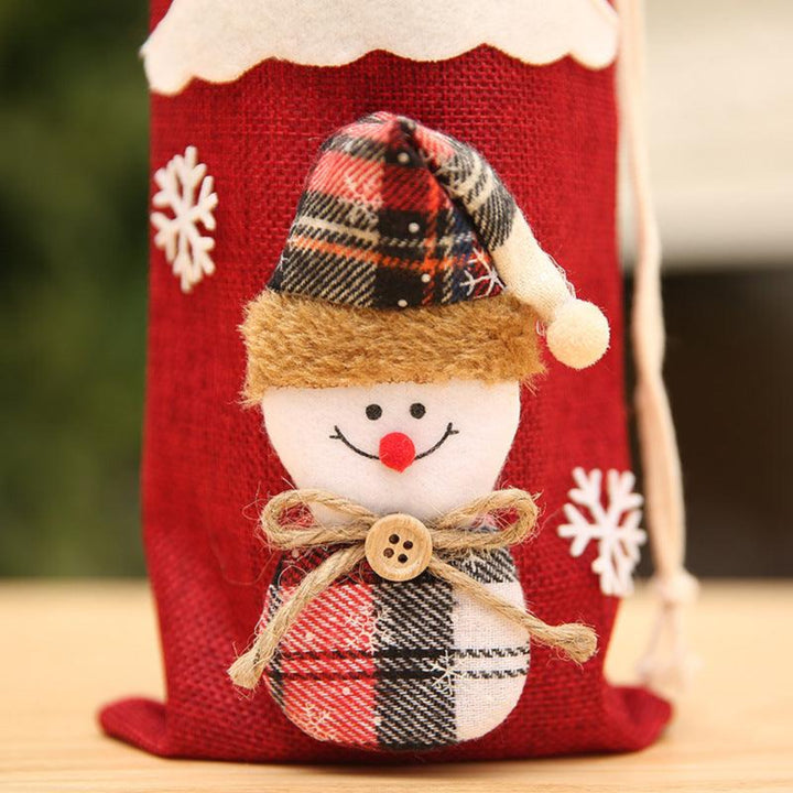 Close-up of linen red bottle cover with a snowman design