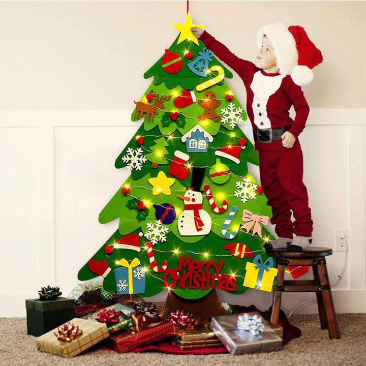 Toddler attaching a star ornament to the top of the felt tree