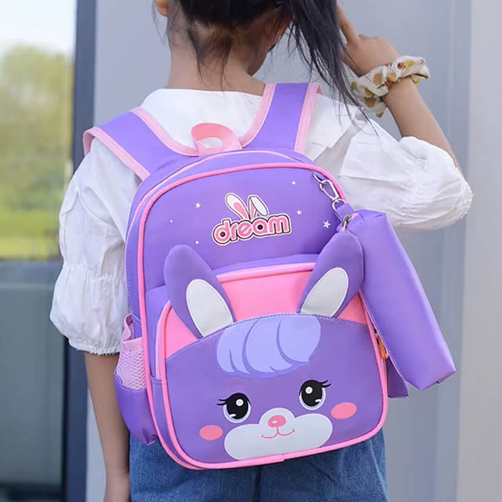Child wearing a purple backpack with a cartoon design and 'dream' text.