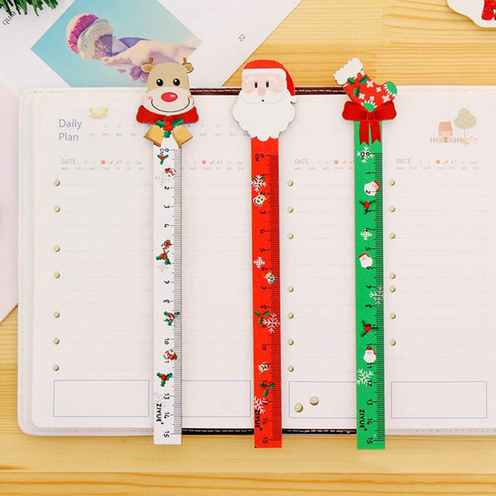 Three decorative rulers with Christmas designs on a planner.